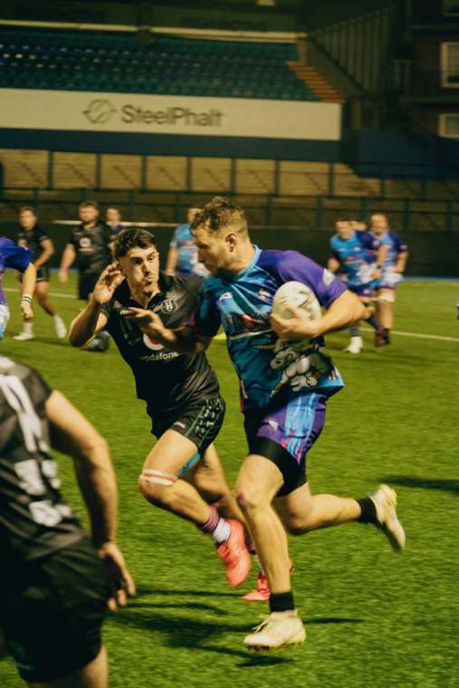 A Tough Enough to Care player carrying into a LooseHeadz tackler