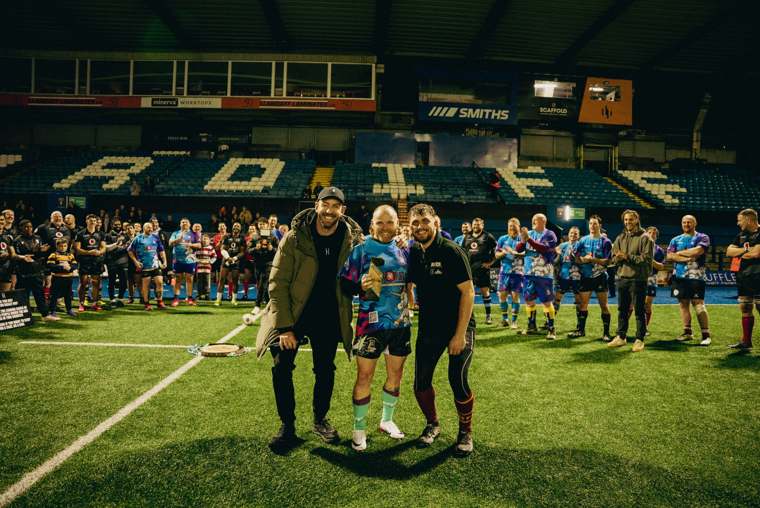Award presentation on the pitch, with both squads clapping behind